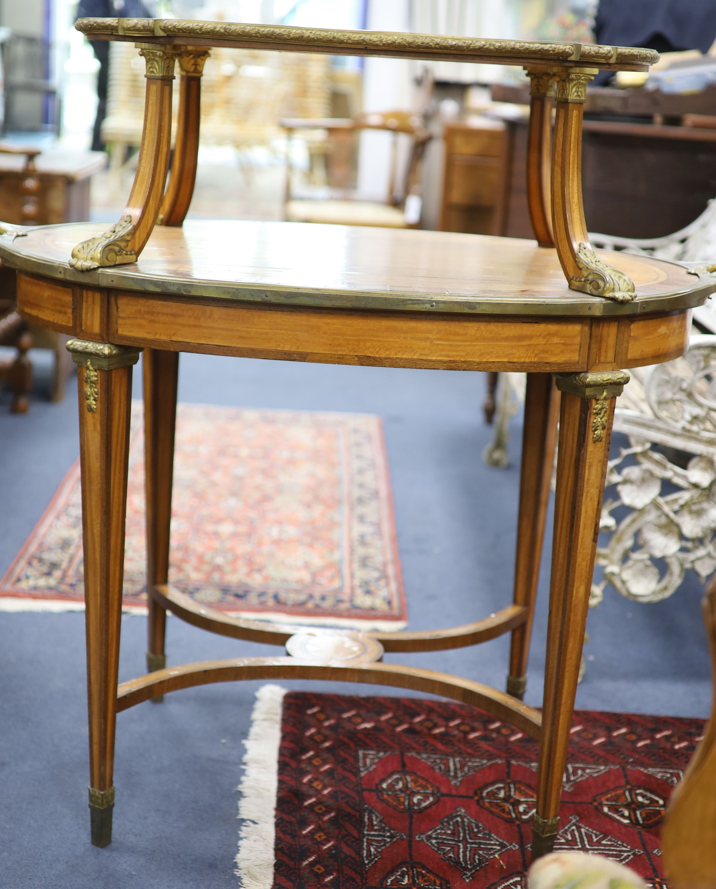 A late 19th century French satinwood, rosewood crossbanded and gilt metal mounted two tier oval etagere,